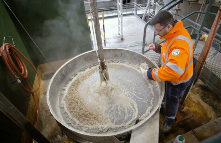 A man extracts tartaric acid from concentrated vinasses